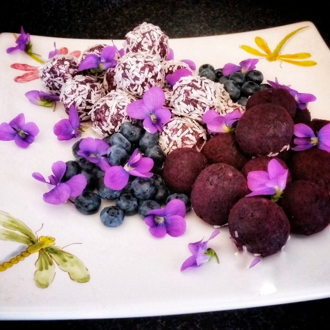 Blueberry Quinoa Truffles plated with violet flowers