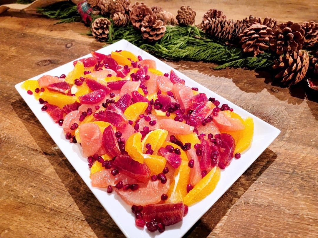 Citrus Salad & Pomegranate on white platter + pine cone background