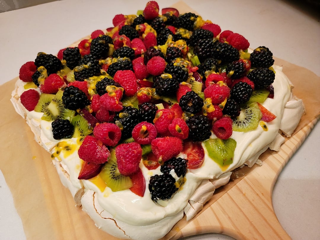 Grandmas Pavlova with cream and berries, kiwi & passionfruit