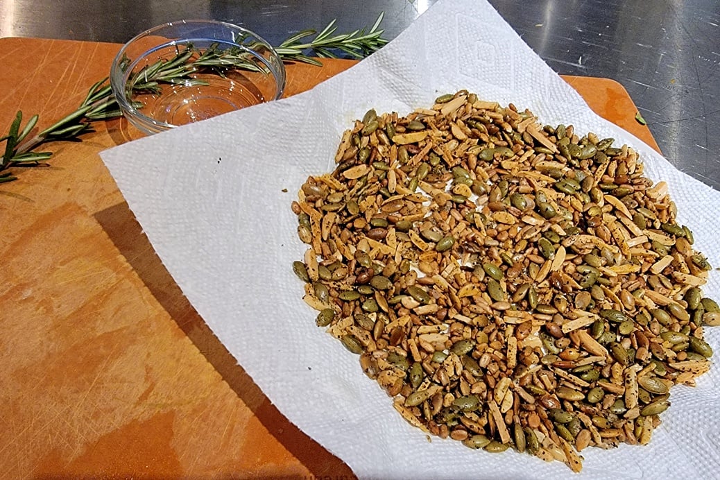 Herb Roasted Pumpkin Seeds & Almonds on white towel + rosemary sprig