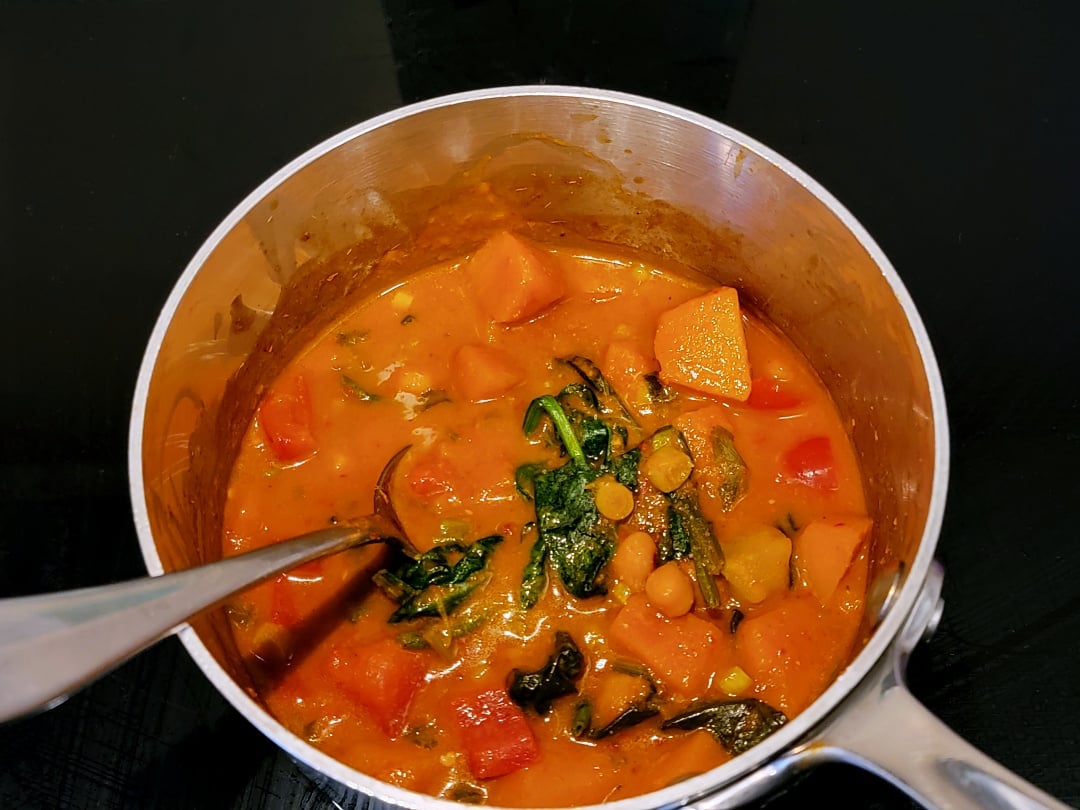 Thai Red Pumpkin Curry in a saucepan + spoon