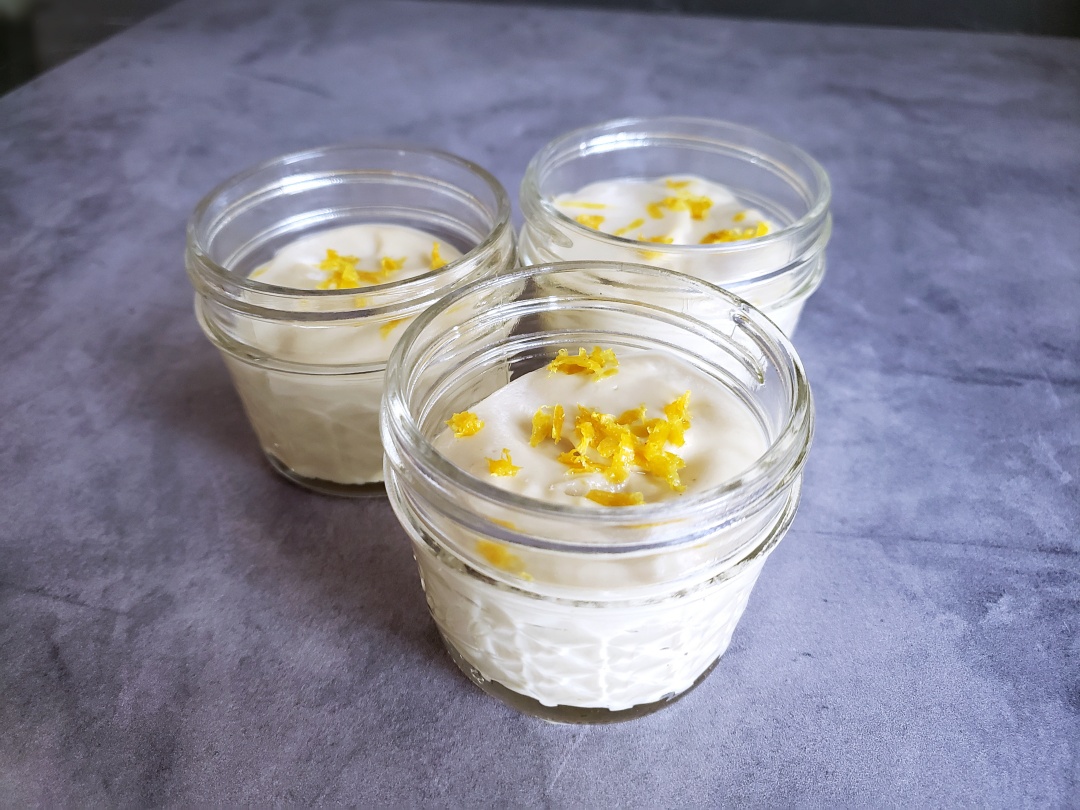 Lemon Cashew Creams in 3 small mason jars with zest garnish
